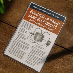 Photographie d’une fiche plastifiée en français posée sur une table en bois, avec le titre « Écouter la radio sans électricité » bien visible et un schéma d’un poste à galène, le reste du contenu étant flouté pour empêcher toute lecture directe